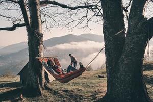 attraktive junge Frau, die beim Camping mit ihrem Freund in der Hängematte liegt foto