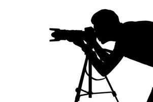 Fotograf bei der Arbeit. Seitenansicht Silhouette des Mannes mit Stativ beim Schießen und Stehen isoliert auf weiß foto