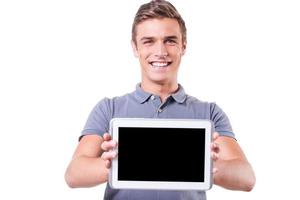 Kopieren Sie Platz auf seinem Tablet. glücklicher junger Mann, der sein digitales Tablet zeigt und lächelt, während er isoliert auf weißem Hintergrund steht foto