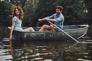 gute Zeiten. schönes junges Paar, das ein romantisches Date beim Rudern eines Bootes genießt foto