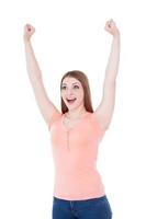 glücklicher Gewinner. glückliche junge lächelnde Frau, die die Arme erhoben hält, während sie isoliert auf Weiß steht foto