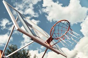 Lasst das Spiel beginnen. Schuss Basketballkorb mit Himmel im Hintergrund im Freien foto