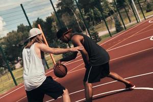 Bleib stark, um zu gewinnen. Zwei junge Männer in Sportkleidung spielen Basketball und verbringen Zeit im Freien foto