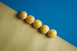 Kuchen aufgereiht auf blauem und gelbem Hintergrund foto