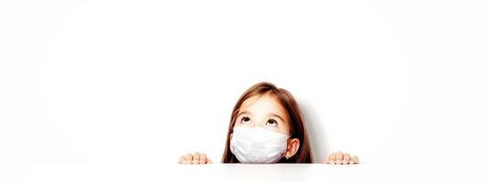 junges Mädchen mit Schutzmaske gegen Corona-Virus in der Schule. foto