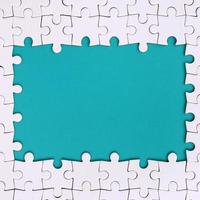 Rahmen in Form eines Rechtecks, bestehend aus einem weißen Puzzle um den blauen Raum foto