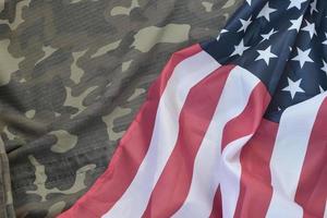 Flagge der Vereinigten Staaten von Amerika und gefaltete Militäruniformjacke. militärische symbole konzeptioneller hintergrundbanner für amerikanische patriotische feiertage foto