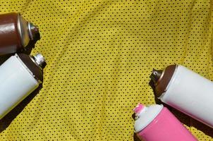 Auf dem Sportshirt eines Basketballspielers aus Polyestergewebe liegen mehrere gebrauchte Farbsprühgeräte. das konzept der jugendlichen straßenkunst, des aktiven sportes und des ereignisreichen lebensstils foto