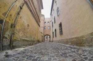 enge Gasse mit einem Weg aus Pflastersteinen. Passage zwischen den alten historischen Hochhäusern in Lemberg, Ukraine foto