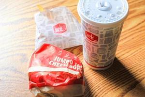 washington, usa - märz, 15 2022 jack in the box hamburger, pommes frites und gläser serviert auf einem braunen holztisch. foto