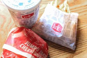 washington, usa - märz, 15 2022 jack in the box hamburger, pommes frites und gläser serviert auf einem braunen holztisch. foto