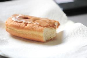 Apfelriegel, Ahornriegel-Donut, Ahornriegel-Donut auf einem weißen Teller in zwei Hälften gebissen. foto