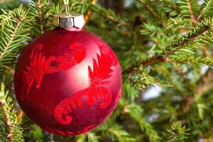 verzierter roter Ball auf grüner Weihnachtsbaumnahaufnahme foto