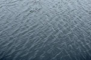 die Textur des Wassers im Fluss unter dem Einfluss des Windes. viele flache Wellen an der Wasseroberfläche foto