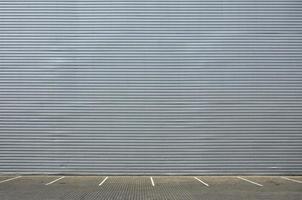 Leere Parkplätze auf dem Hintergrund einer Metallwand mit Platz für die Produktplatzierung foto