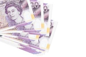 20 britische Pfund-Scheine liegen in kleinen Bündeln oder Packungen isoliert auf Weiß. modell mit kopierraum. Geschäft und Geldwechsel foto