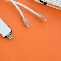 internetrouter, tragbarer usb-wi-fi-adapter und internetkabelstecker liegen auf einem leuchtend orangefarbenen hintergrund. Elemente, die für die Internetverbindung erforderlich sind foto