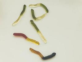 helle, leckere, schöne, saftige, mehrfarbige, gallertartige, gummiartige, süße Bonbonwürmer liegen auf einem weißen Hintergrund foto
