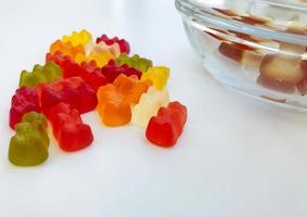 gallertartige, mehrfarbige, volumetrische Bären auf einem weißen, matten Hintergrund. köstliche und süße Bonbons. Nachtisch für Kinder und Erwachsene. Meisterwerk des Küchenchefs foto