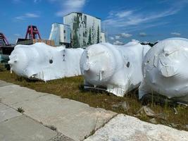 große Wärmetauscher werden im Lager von Industrieanlagen und Materialien in Kartons am Lagerort in Folie verpackt, vorübergehende Lagerung vor der Installation foto