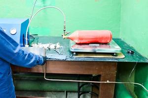 professionelle Industrieausrüstung, Ladestation für Feuerlöscher mit Manometern und Schläuchen in der Werkstatt im Werk foto