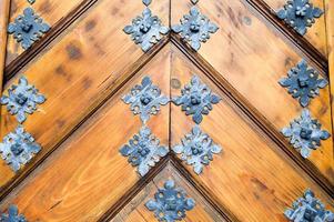 Textur der alten, mittelalterlichen, robusten, natürlichen, dicken Holztür mit Nieten- und Nagelmustern und Schlössern aus Holzbohlen. der Hintergrund foto