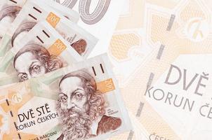 200 tschechische Korun-Scheine liegen im Stapel auf dem Hintergrund einer großen halbtransparenten Banknote. abstrakter betriebswirtschaftlicher hintergrund foto