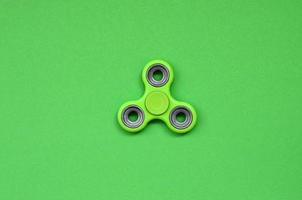 grüner zappelspinner liegt auf texturhintergrund von modepastellgrünem farbpapier in minimalem konzept foto