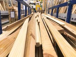 Holzbraun gesägte Naturbauplatten kleben Baumstämme mit Knoten auf einem Gestell auf einem Sägewerk im Laden. der Hintergrund foto