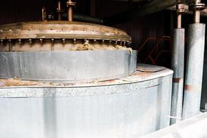 Metalldeckel aus Edelstahl mit Schrauben und Nieten, Oberseite des Wärmetauschers einer chemischen Rektifikationssäule mit einem Rohr mit Flanschen in einer petrochemischen Industrieraffinerie foto