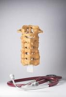 künstliches menschliches Halswirbelsäulenmodell und Stethoskop foto