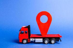 roter LKW trägt eine rote Zeigerposition. Dienstleistungen Transport von Waren und Produkten, Logistik und Infrastruktur. Transportunternehmen Lagerung und Versorgung. Ortung und Kontrolle von Spediteuren. foto