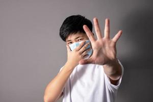 asiaten tragen sterile medizinische masken auf ihren gesichtern und zeigen eine handbewegung, um die ausbreitung des virus zu stoppen, das virus zu stoppen. foto