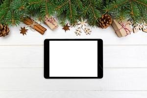 digitales tablet-modell mit rustikalen weihnachtlichen hölzernen hintergrunddekorationen für app-präsentation. draufsicht mit kopierraum foto