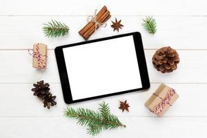 digitales tablet-modell mit rustikalen weihnachtlichen hölzernen hintergrunddekorationen für app-präsentation. draufsicht mit kopierraum foto