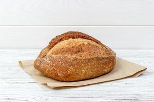 frisches Brot auf Holztisch. Brot auf Papiertüte foto