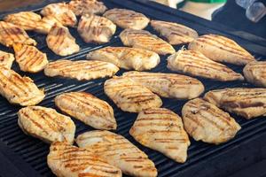 gegrillte Hähnchenfilets auf dem Grill. Straßenessen. foto