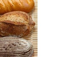 verschiedenes frisches Brot auf Holzbrett, isoliert auf weißem Hintergrund foto