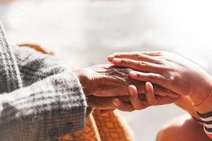 die Tochter tröstete die alte Frau und erhob ihre Hand zu ihr. Gespräch, das eine starke Beziehung ist, Mitgefühl und Sympathie, Unterstützung in einem schwierigen Leben. foto