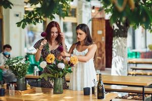 Zwei junge Frauen bilden einen schönen festlichen Blumenstrauß. foto