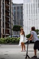 schöne hübsche frau im weißen kleid, das an der stadtstraße geht foto