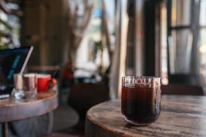 Glas mit Tee auf einem Holztisch, unscharfer Hintergrund foto