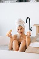 luxusmodefrau morgens frühstücken im bad liegend foto