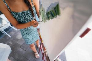 junge künstlerin malt mit einem spachtel auf der leinwand foto