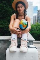 Schöne junge Frau hält einen kleinen Globus in ihren Händen. foto