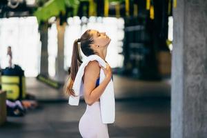 gesunde junge frau entspannt nach dem training im fitnessstudio. foto