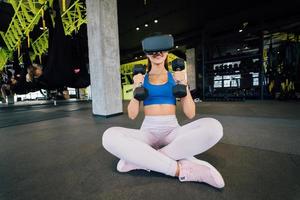 Frau mit Brille der virtuellen Realität, die mit Hanteln trainiert foto