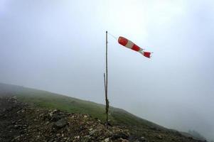 Alter gestreifter Windsack, Indikator für Windstärke und -richtung in den Bergen des Kaukasus im Nebel foto