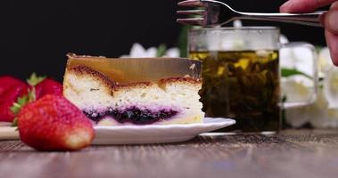 Teilen Sie den Kuchen mit Gelee- und Beerenfüllung mit einer Gabel foto