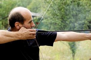 Mann schießt mit Bogen foto